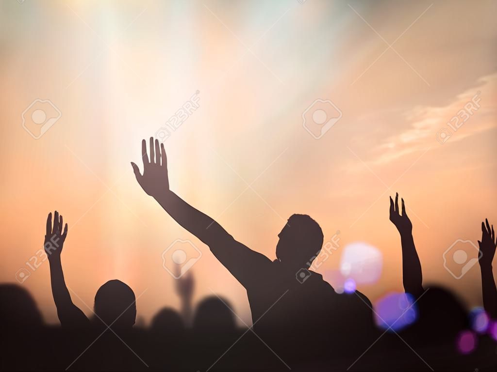 Crença, louvor e conceito de adoração: Silhouette pessoas cristãs mão levantando-se sobre a cruz turva no fundo da luz espiritual