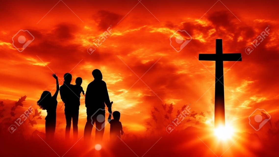 Conceito de louvor e adoração: Família cristã de Silhouette que procura a cruz no fundo do nascer do sol do outono