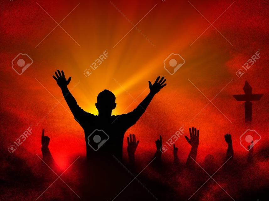 Concetto di lode e adorazione: Silhouette umana che alza le mani per pregare Dio sulla croce sfocata con la corona di spine sullo sfondo del tramonto