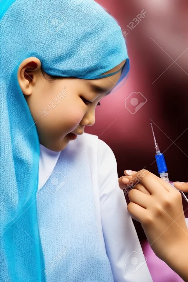 Doctor give injection to Asian girl s arm