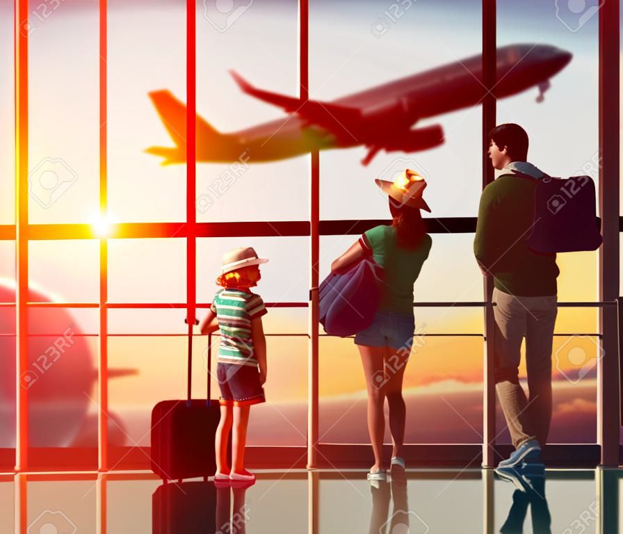 Счастливая семья с чемоданами в аэропорту.