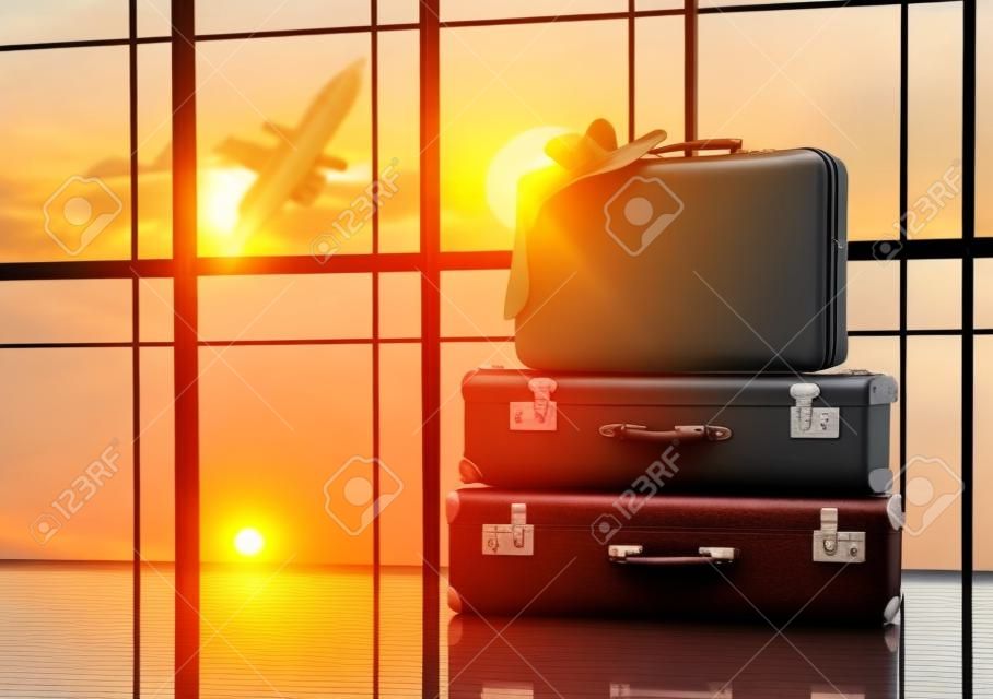 旅行和假日手提箱靠窗和日落的概念