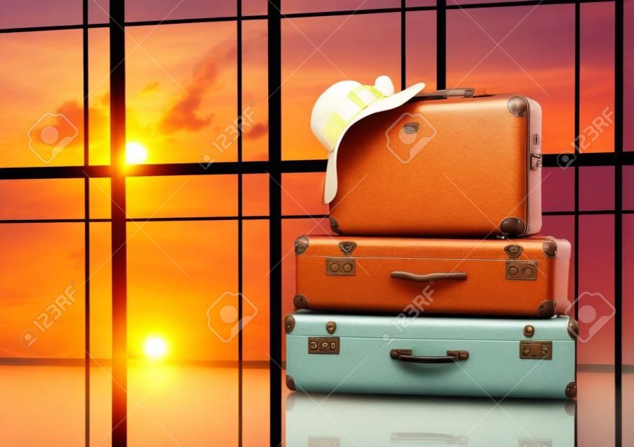 여행과 휴가의 개념. 창문과 석양에 대한 여행 가방