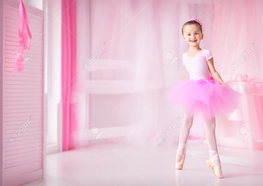 Jolie petite fille rêves de devenir une ballerine. fille de l'enfant dans une danse de tutu rose dans une chambre. Baby girl étudie le ballet.