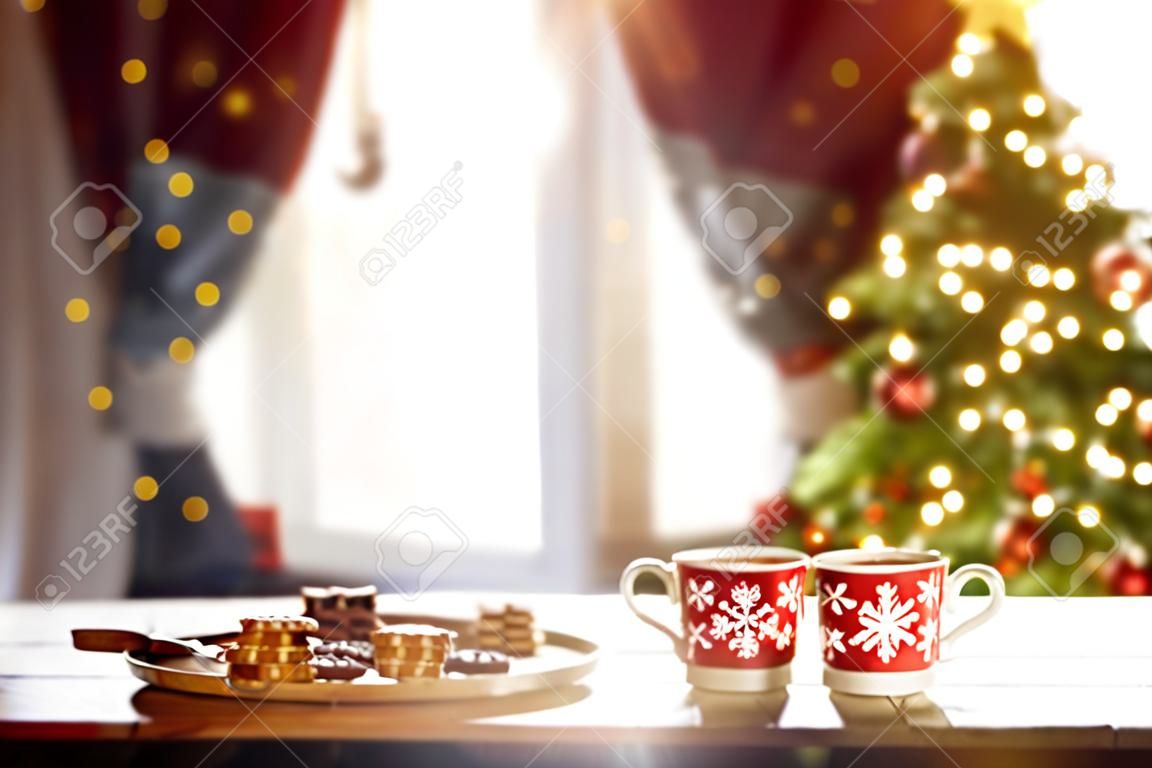 Merry Christmas and Happy Holidays. Time of family tea party. Cups of warm tea with Christmas cookies on wooden table.