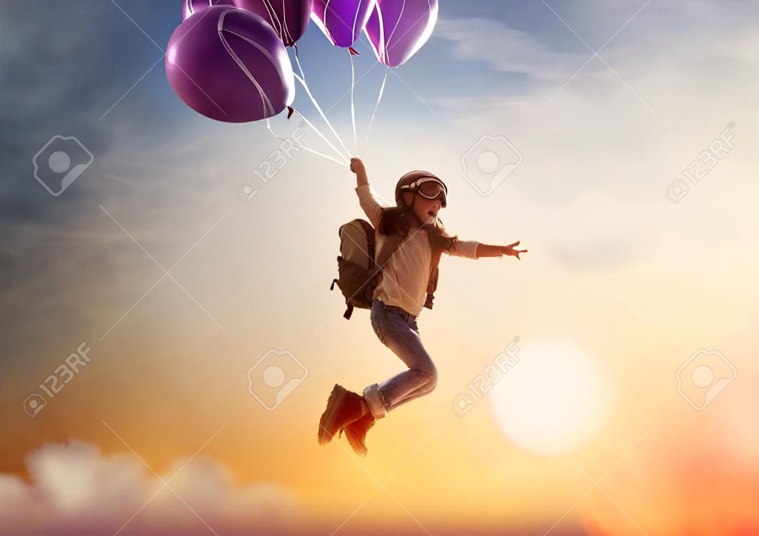 여행의 꿈! 아이는 석양을 배경으로 풍선 비행입니다.