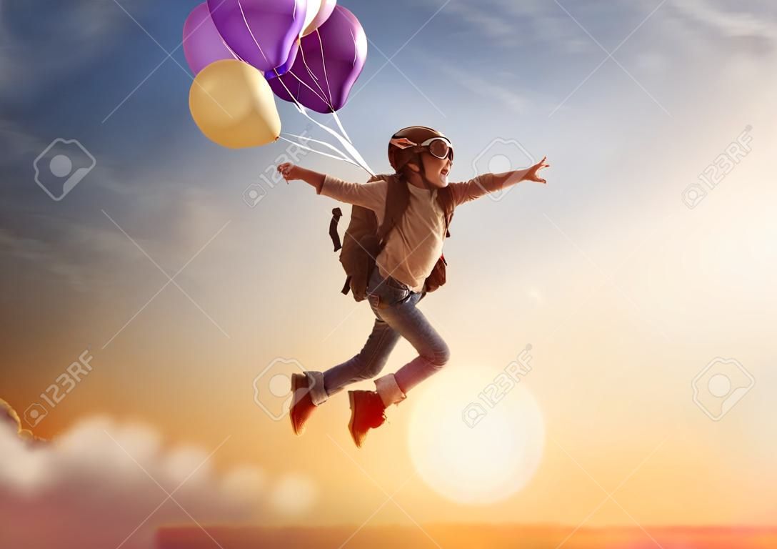 旅行的夢想！兒童飛行在對夕陽的背景下氣球。