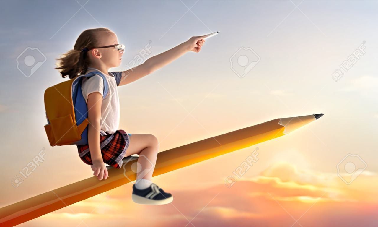 Di nuovo a scuola! Bambino industrioso sveglio felice che vola sulla matita sullo sfondo del cielo al tramonto. Concetto di educazione e lettura. Lo sviluppo dell'immaginazione.
