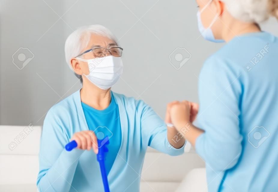 Dorosła córka i starszy rodzic noszący maski na twarz podczas epidemii koronawirusa i grypy. pomoc dla rekonwalescenta.
