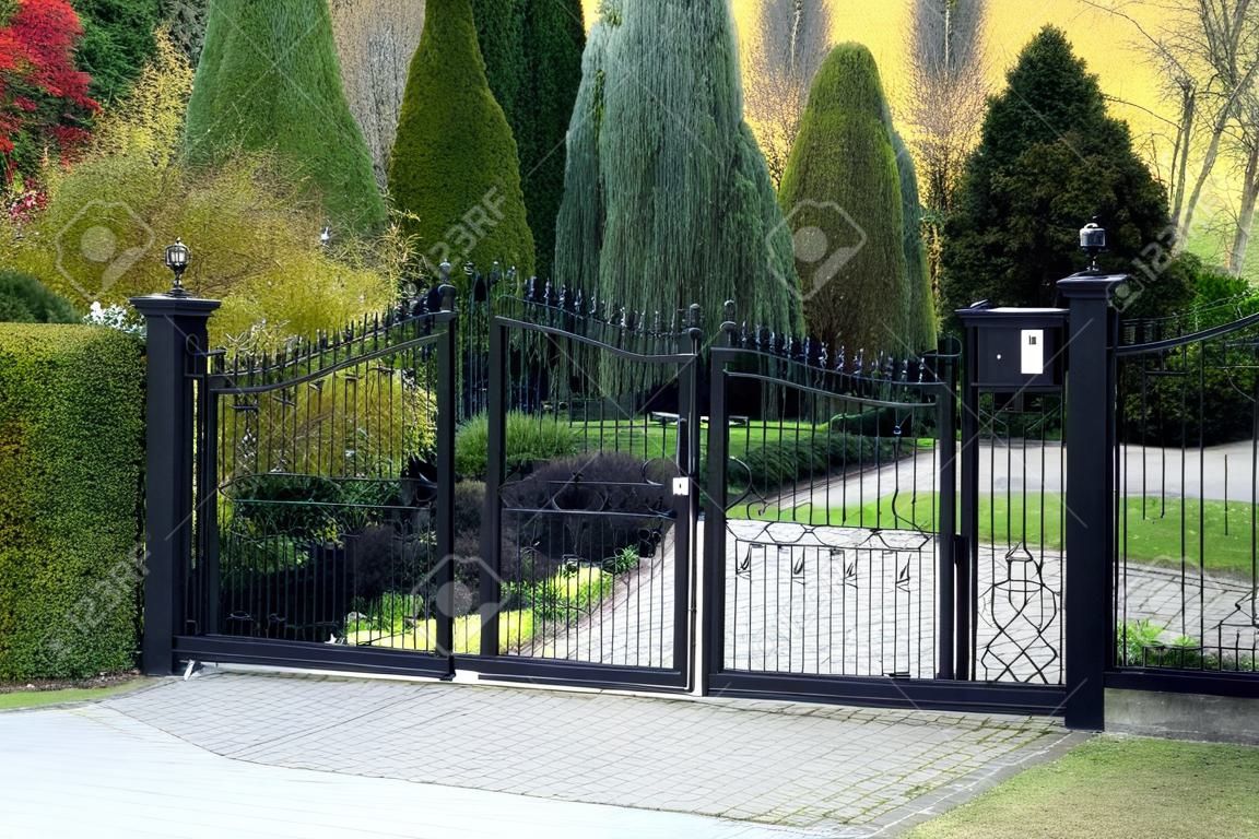 黑色的鐵藝大門，物業帶花園的背景