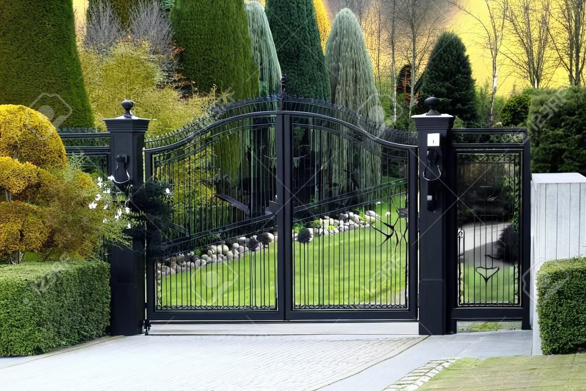 preto forjado portão para a propriedade com jardim no fundo