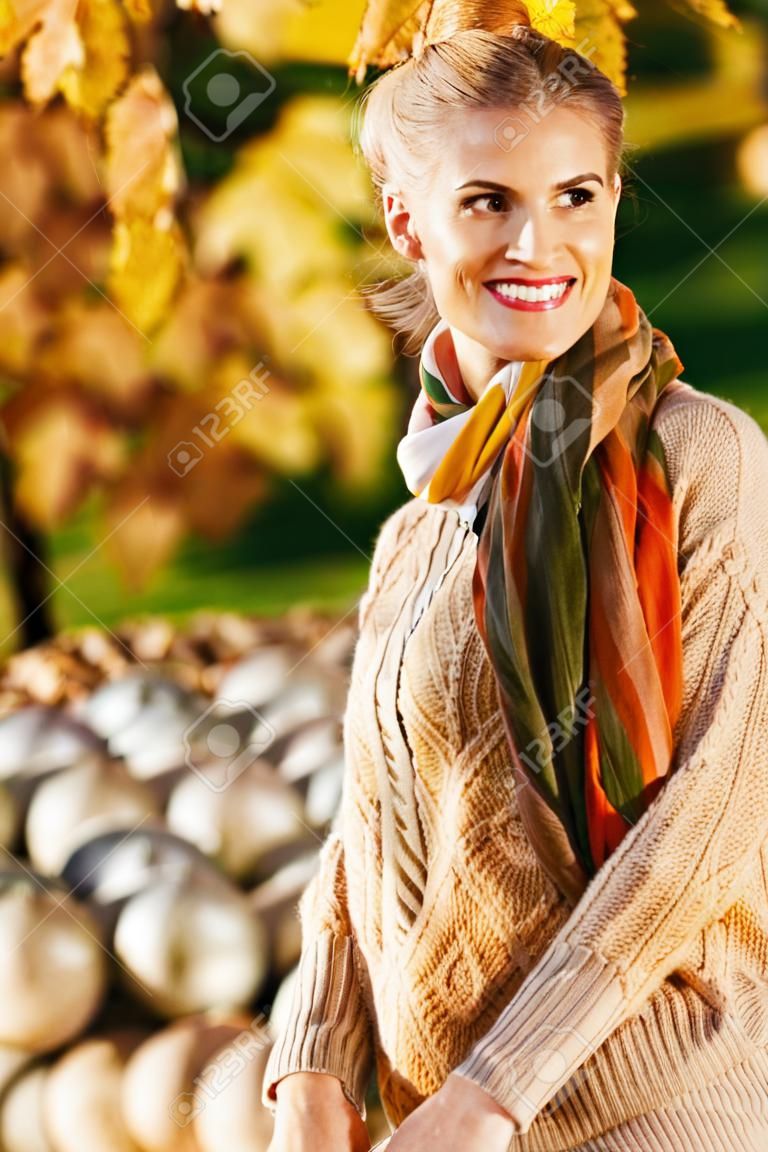 우아한 갈색 머리 여자 가을 공원에서 휴식을 웃고