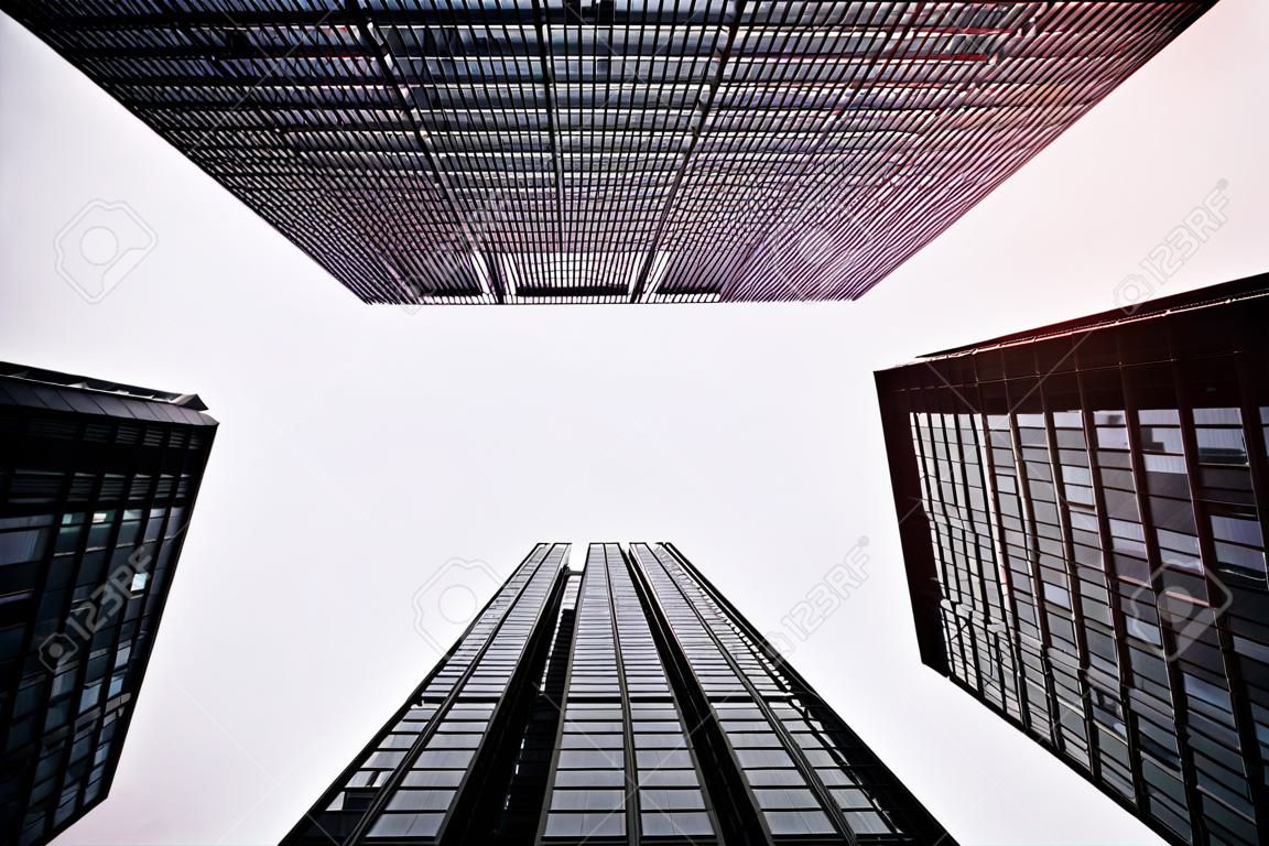 Um tiro de baixo ângulo de edifícios de escritórios altos em um dia nublado.