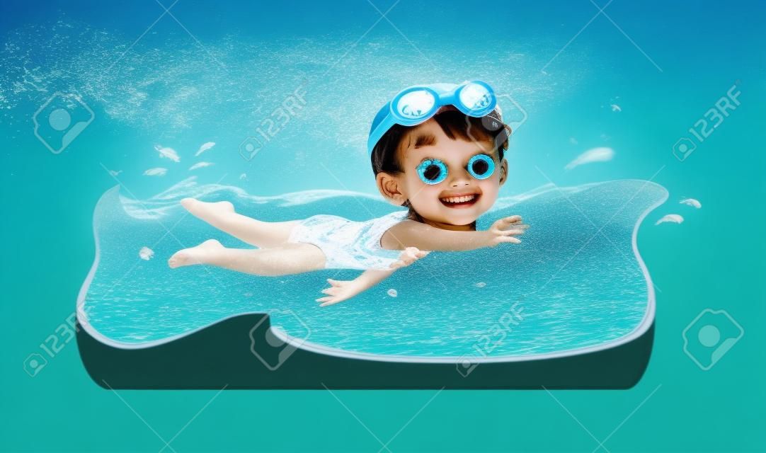 かわいい小さな子供の女の子は夏休みに水の下で泳ぐ
