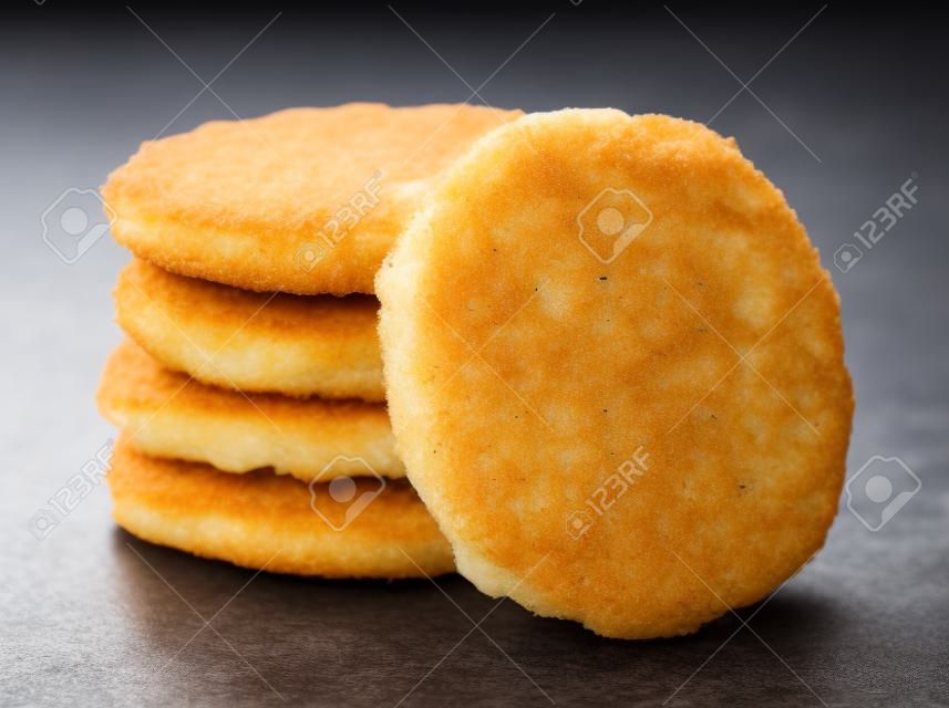 Stack of frozen breaded fish patties isolated on white