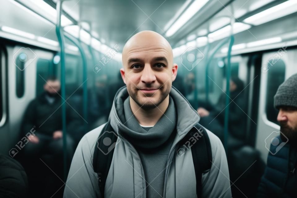 Portret łysego mężczyzny w wagonie metra patrzącego w kamerę