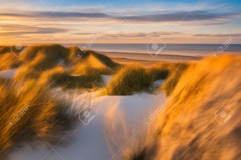 Vista desde la parte superior de la duna sobre la puesta de sol en el Mar del Norte desde la isla de Ameland, Frisia, Países Bajos