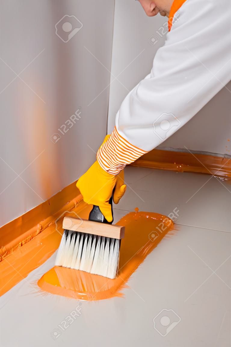 constructeur pinceau appliqué étanchéité sur le plancher de la salle de bain