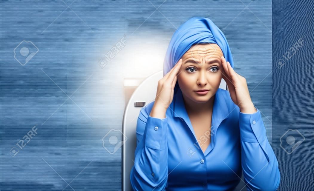 Geschäftsfrau in der Toilette mit Problemen der Verstopfung