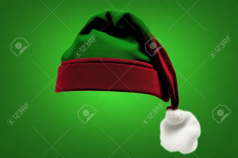 Boże Narodzenie santa hat na białym tle na zielonym tle. przeznaczony do łatwego zakładania na głowę osoby.