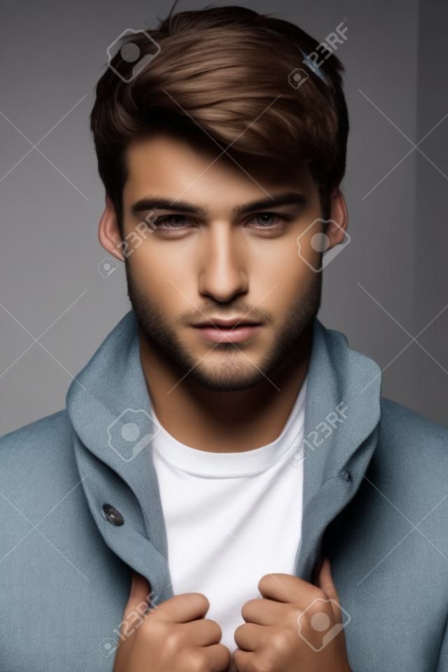 Ritratto di un giovane modello maschile con grande faccia e le mani sulla giacca