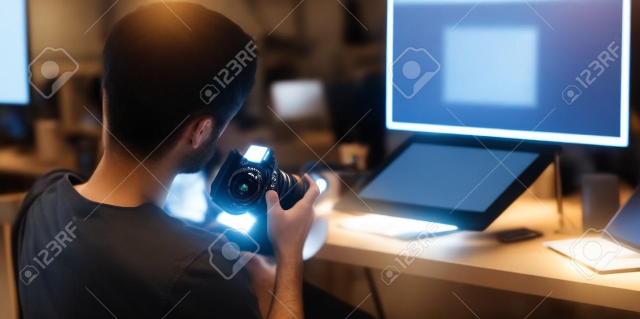 Close-up view of motivated photographer checking his camera in his modern workplace