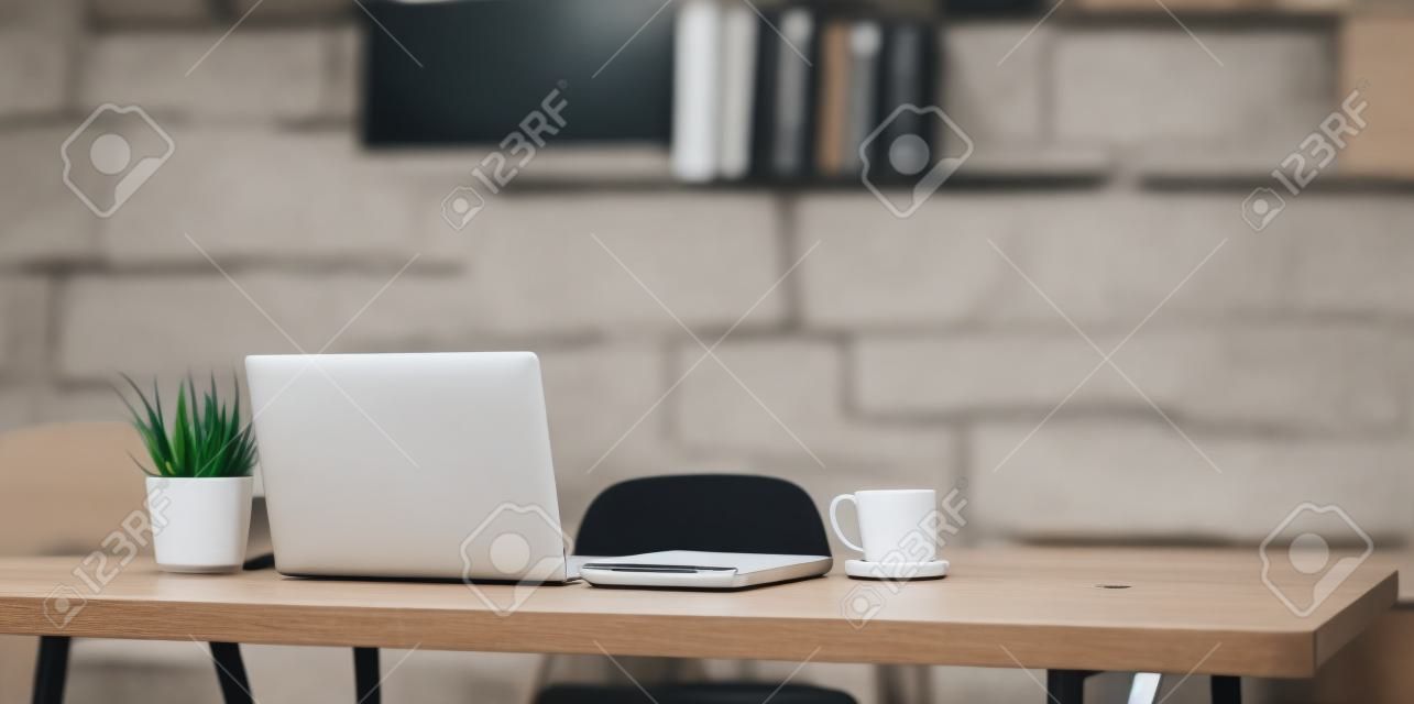 편안한 분위기의 노트북 컴퓨터, 커피 컵 및 사무용품이 있는 편안한 작업 공간