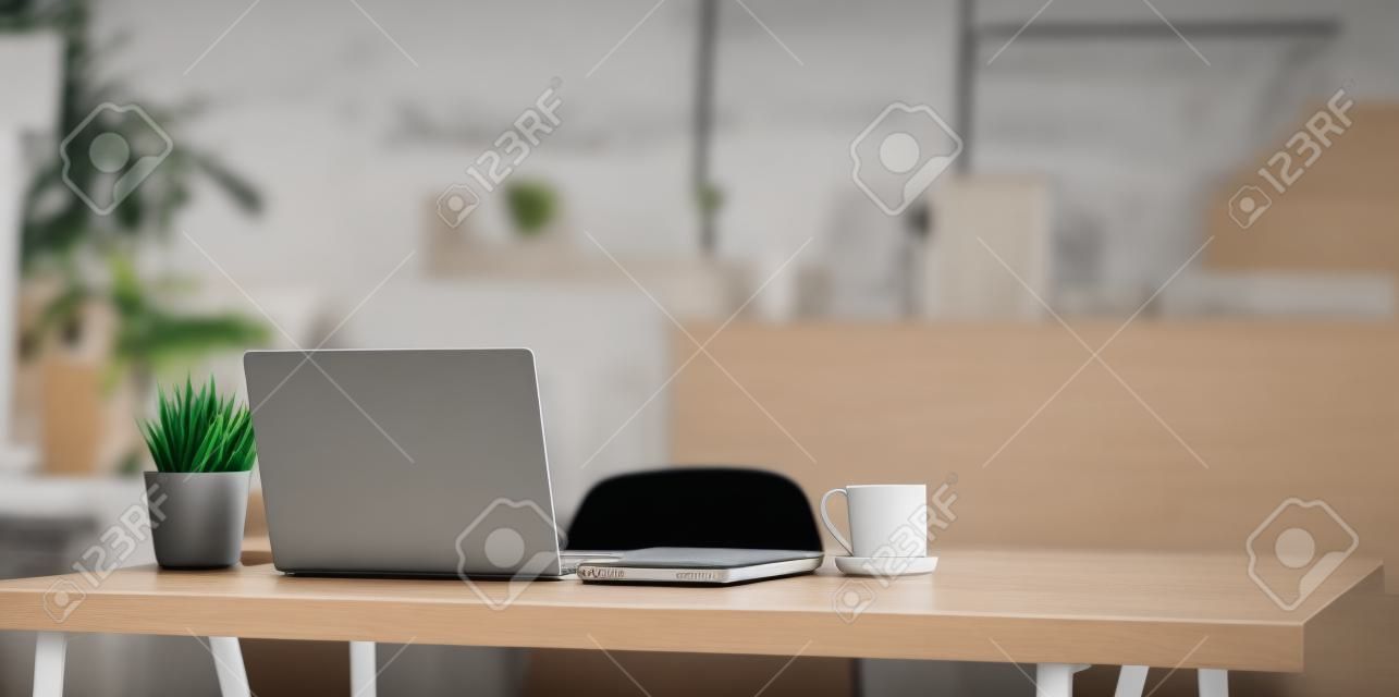 편안한 분위기의 노트북 컴퓨터, 커피 컵 및 사무용품이 있는 편안한 작업 공간