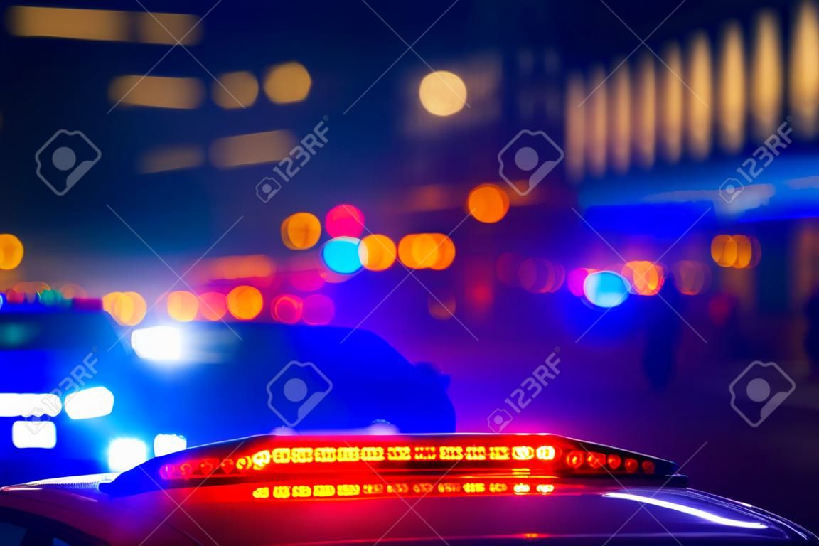 police car with lights flashing with red and blue colors on blurred background of city street