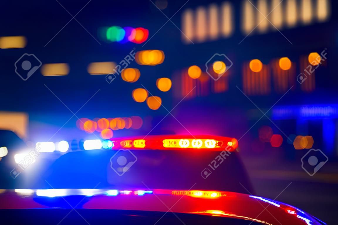 police car with lights flashing with red and blue colors on blurred background of city street