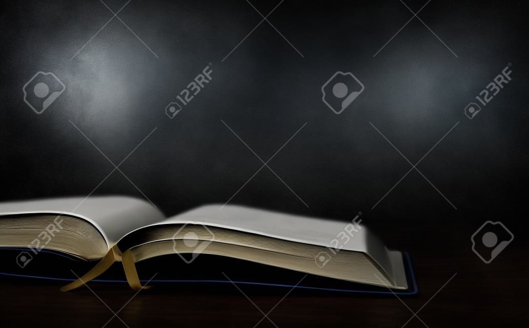 Bible on the table on the dark room background