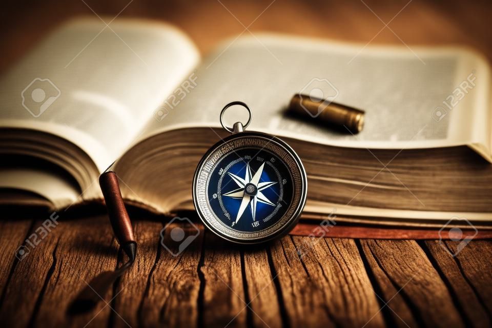 Kompass mit Bibel auf dem hölzernen Hintergrund