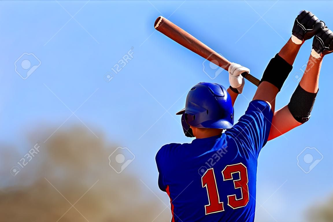 Baseball player holding baseball bat. Copy space