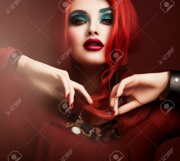 Mode Studio Portrait der wunderschöne Frau mit dunklen Haaren und hellen Make-up mit luxuriösen bijou, massiven Halsketten und Armbänder