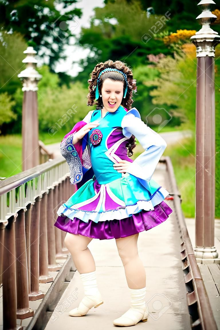 Young beautiful girl in irish dance dress and wig having fun outdoor