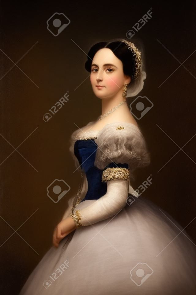 Una bella ed elegante donna dai capelli scuri in uno storico abito da incoronazione del 1867 su sfondo bianco guarda la telecamera