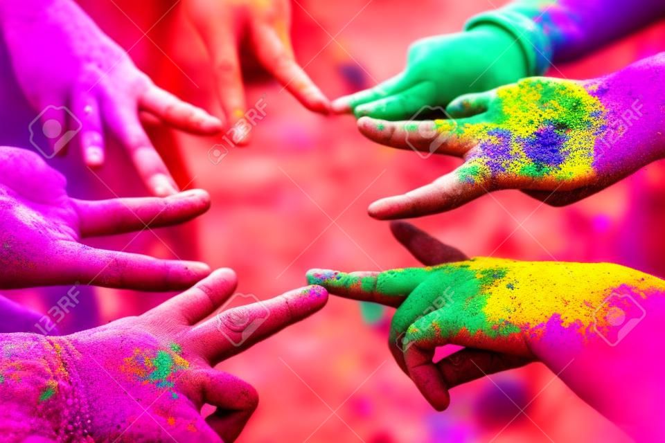 Vrienden die hun handen bij elkaar steken in een teken van eenheid en teamwork. Holi colours festival. Vriendschap concept