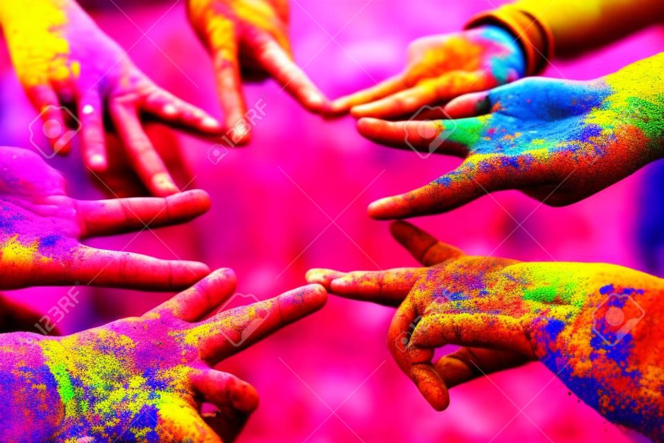 Vrienden die hun handen bij elkaar steken in een teken van eenheid en teamwork. Holi colours festival. Vriendschap concept