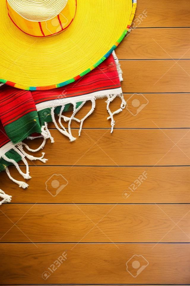 멕시코 솜브레로와 전통적인 serape 담요 노란색 페인트 소나무 나무 바닥에 누워. 복사본을위한 공간.