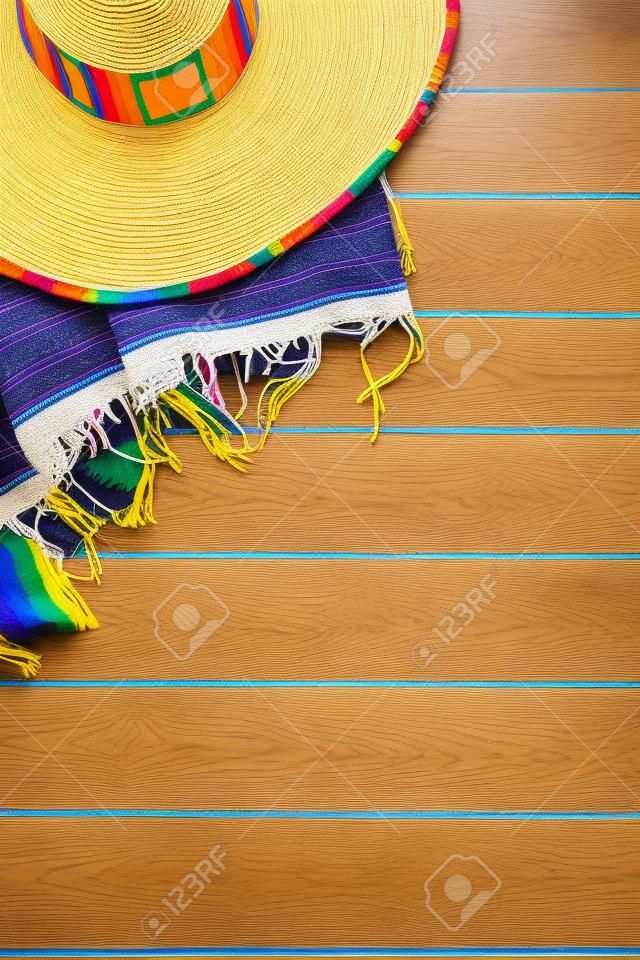 Mexican sombrero and traditional serape blanket laid on a yellow painted pine wood floor.  Space for copy.