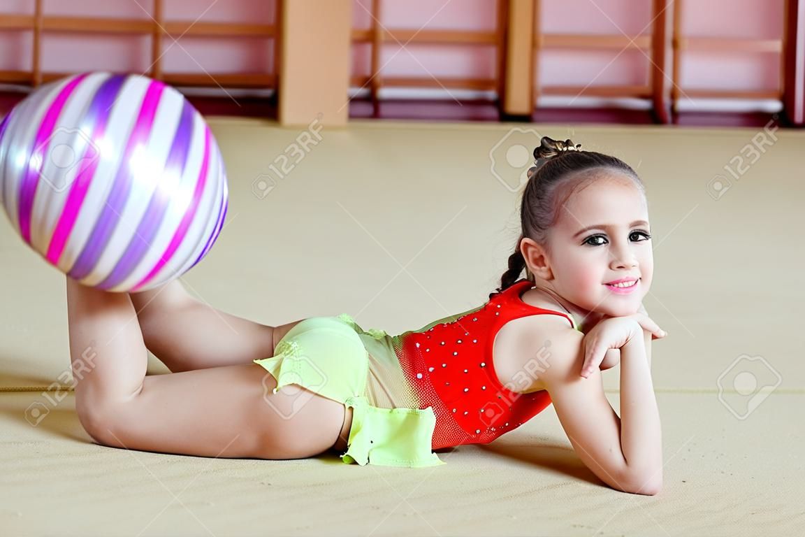 Jong meisje die gymnastiek doet in de sportschool.