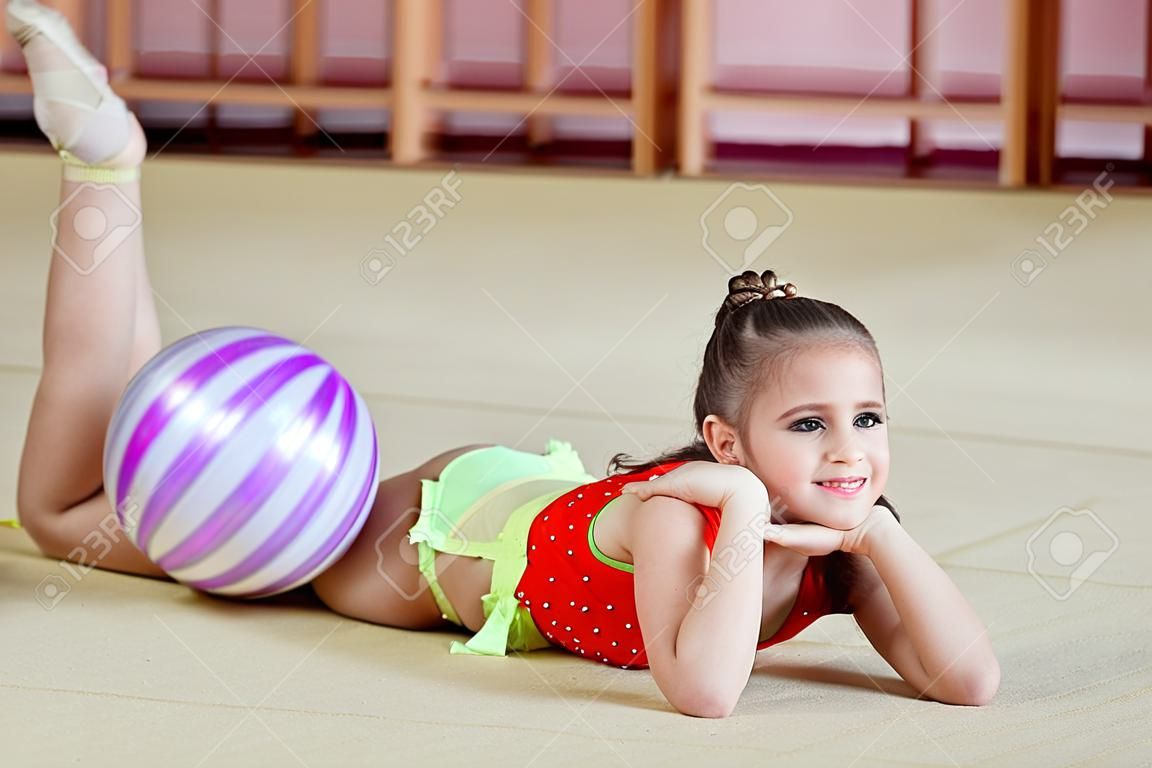 Jong meisje die gymnastiek doet in de sportschool.