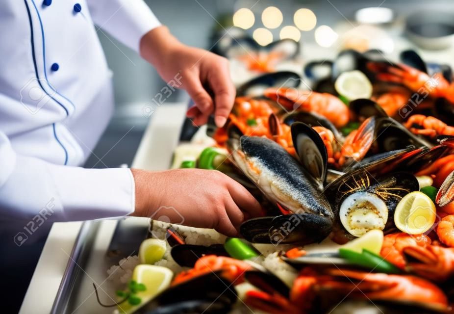 Der Küchenchef legt die Meeresfrüchte im Restaurant auf ein Tablett.