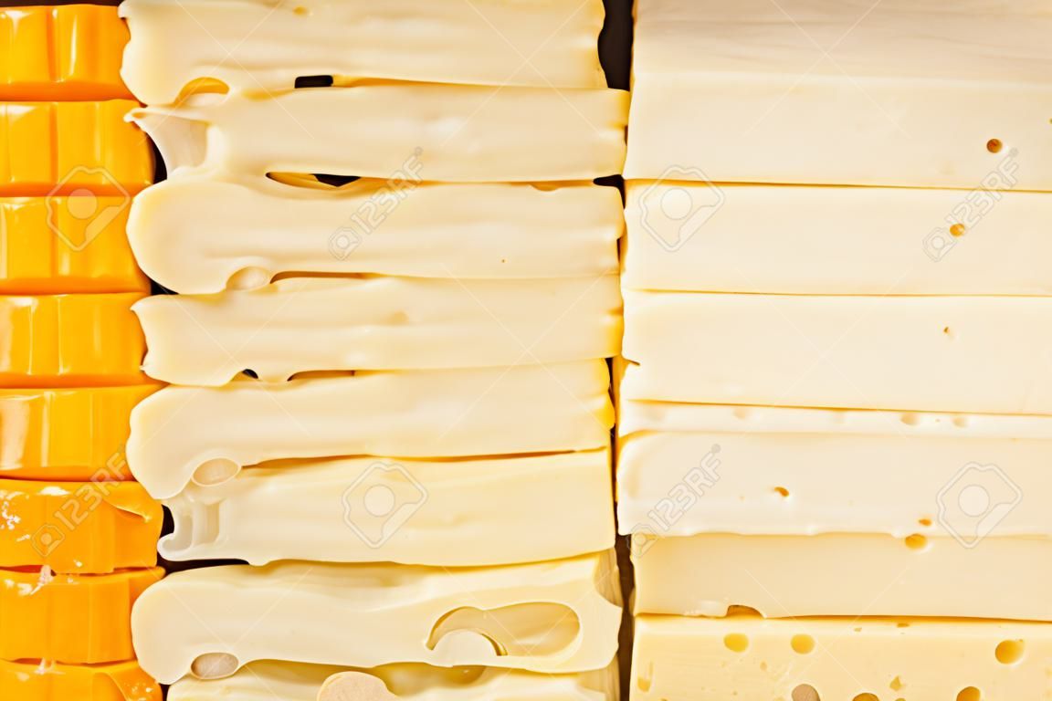 Quatro tipos de queijos fatiados em um balcão de deli