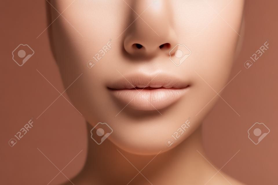 Close up photo of woman's face with perfect skin and lips