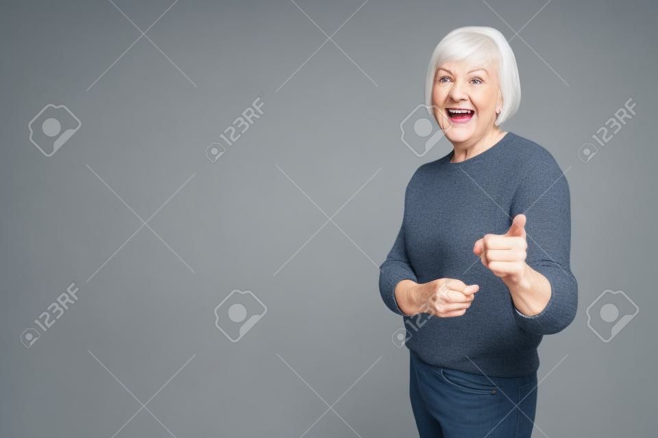 Kendine güvenen modern büyükanne iki işaret parmağı bir portresi