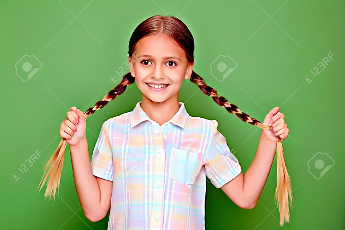 Close up photo small little age she her girl hold hand arm showing tails pigtails positive optimistic nice pretty wear casual checkered plaid shirt isolated green bright vibrant vivid background.