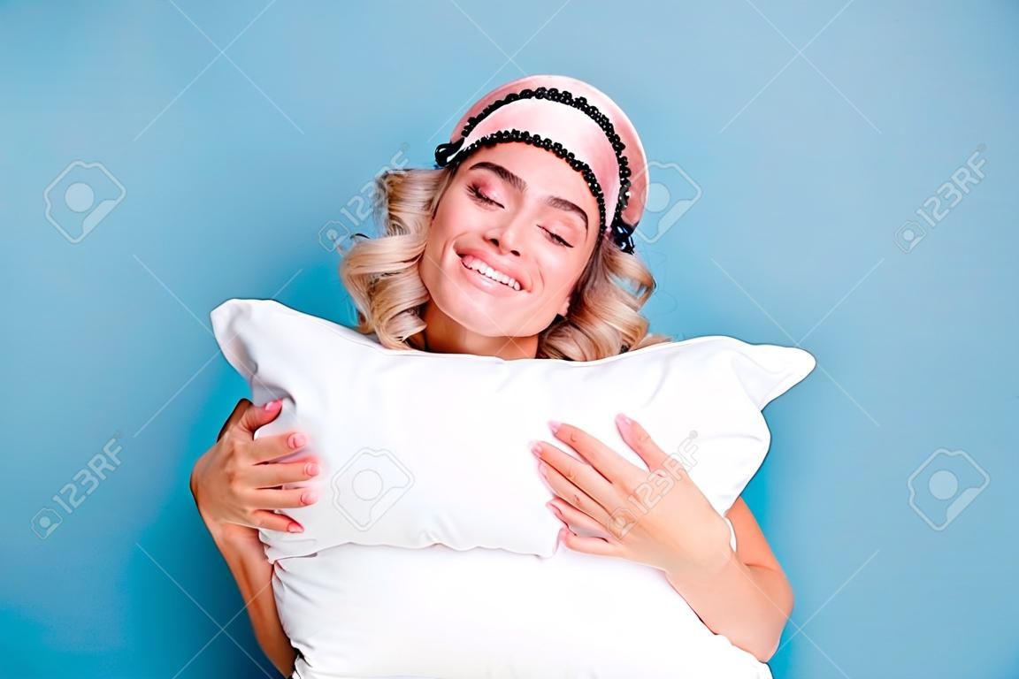 Close up photo beautiful funky her she lady white teeth hands arms palms hold cuddle big large pillow glad day off wear sleeping pink mask casual white t-shirt clothes isolated blue background