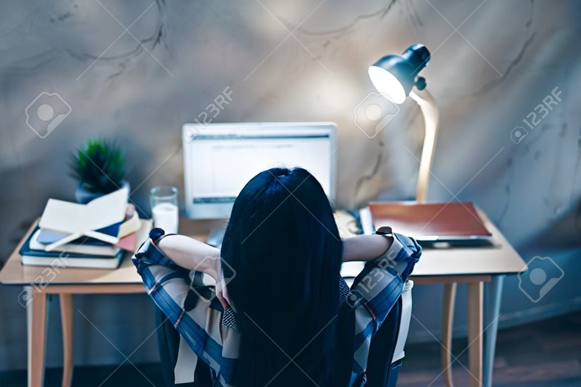 Rear back behind view of nice attractive brunette lady in checked shirt resting after well done examination preparation industrial loft style interior work place station