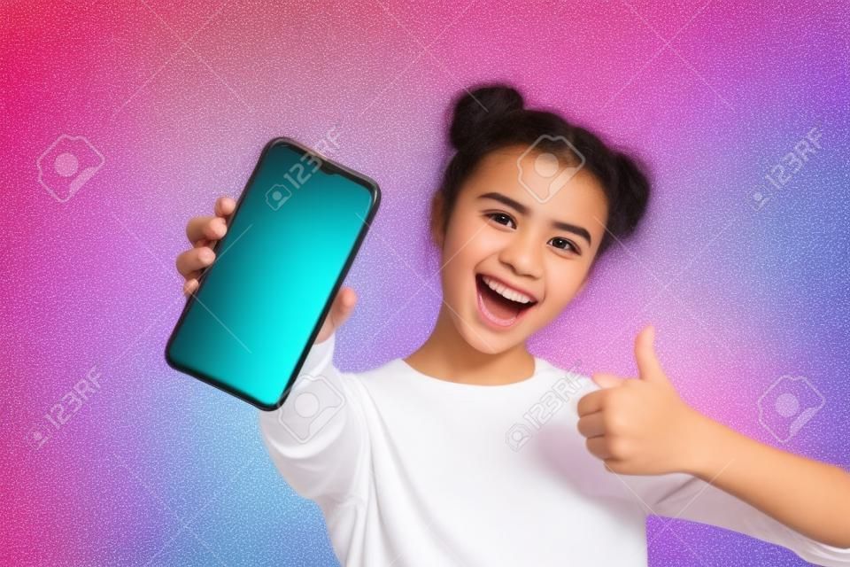 Close up foto van funky energieke student toont haar mobiele telefoon overeenkomst waardering dragen licht katoen outfit op kleurrijke achtergrond